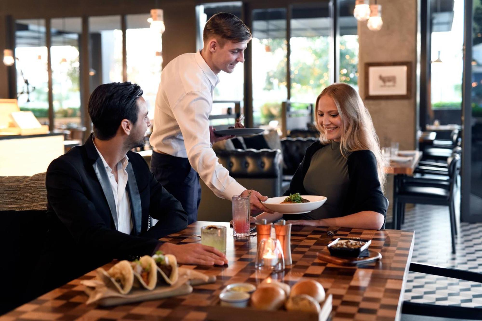 La Ville Hotel & Suites City Walk Dubai, Autograph Collection Exteriér fotografie A waiter serving a couple